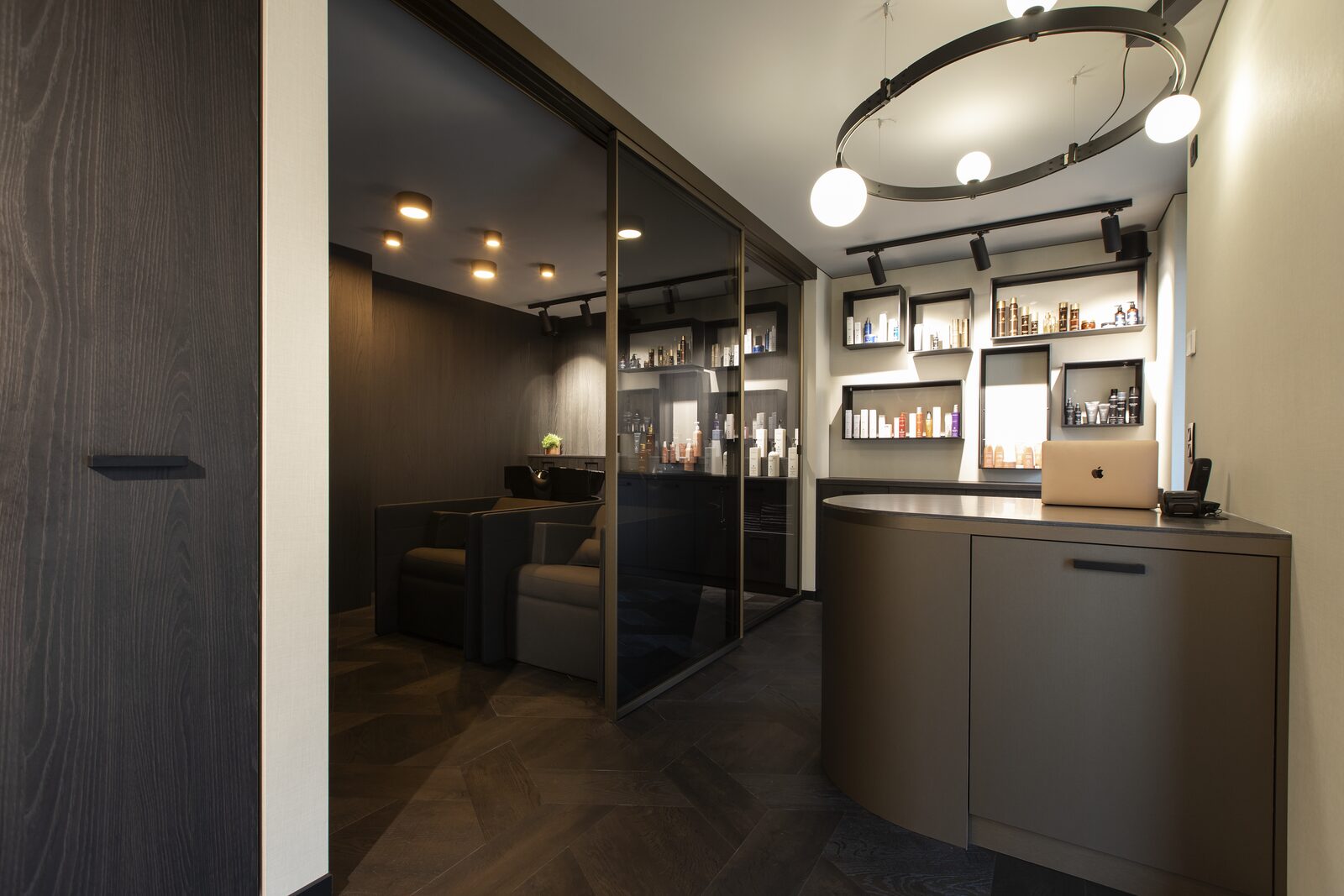 Het interieur van Colorian in Maasmechelen, met walnoothout, goud en zwarte accenten in hotelstijl