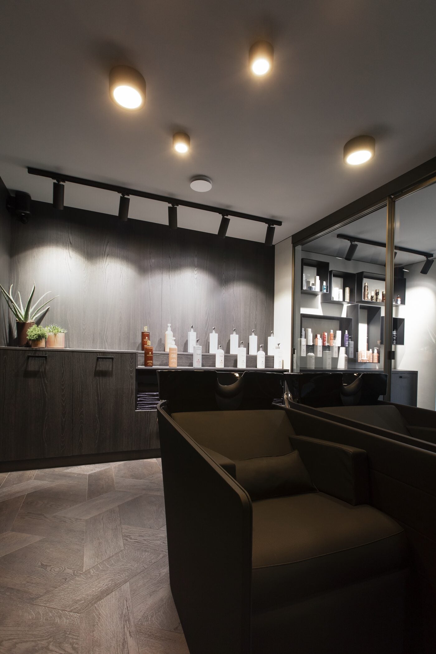 De privé wasruimte van Colorian met massagezetels, donker walnoothout en verzorgingsproducten